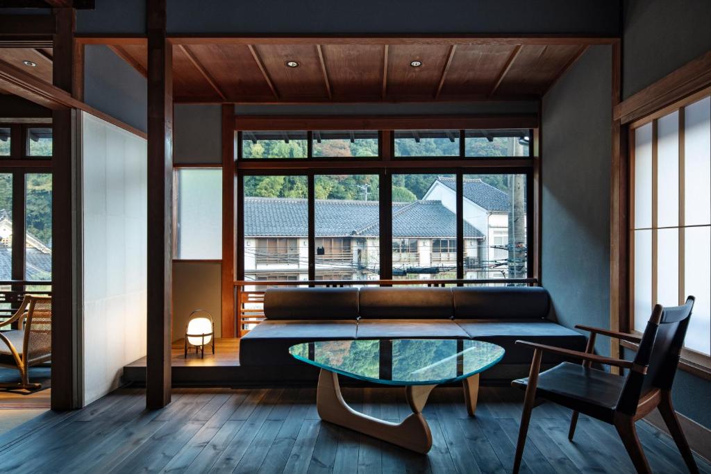 un salon avec une table en verre et un canapé dans l'établissement Kobayashiya -Kinosaki Onsen-, à Toyooka