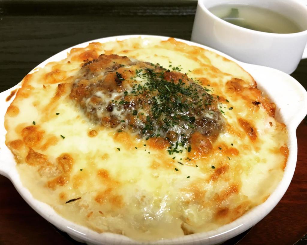 une pizza au fromage posée sur une assiette sur une table dans l'établissement H-SEVEN TOYAMA (Adult Only), à Takaoka