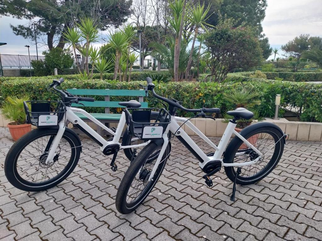 deux vélos garés à côté d'un banc vert dans l'établissement Hotel Parco Carabella, à Vieste