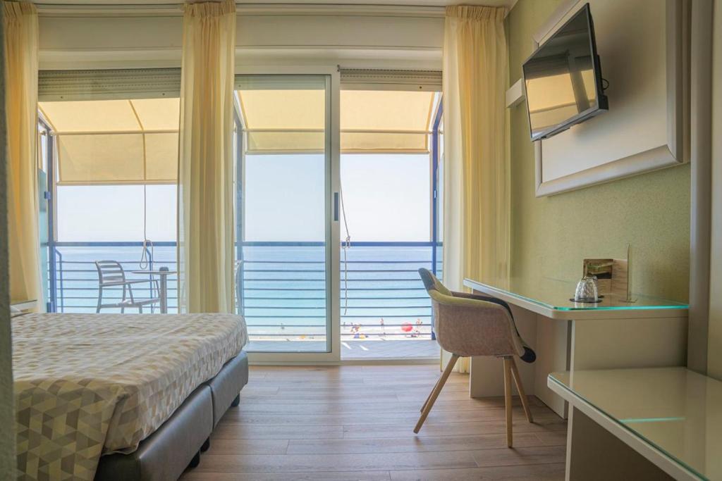 une chambre avec un lit et un bureau avec vue sur l'océan dans l'établissement Hotel 4 Venti spa & wellness, à Sestri Levante
