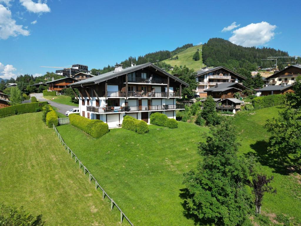 une maison sur une colline avec un champ vert dans l'établissement Chalet Les Combes, à Notre-Dame-de-Bellecombe 16 autres photos