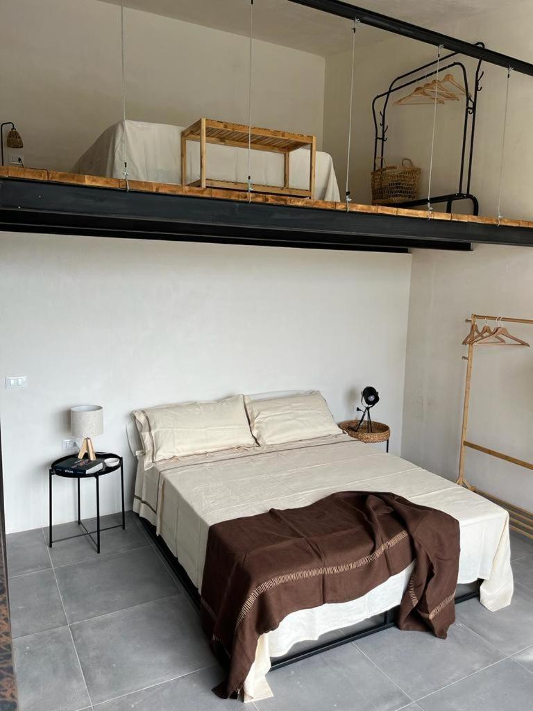 - une chambre avec un grand lit et des étagères murales dans l'établissement Villa Calimma, à Pachino