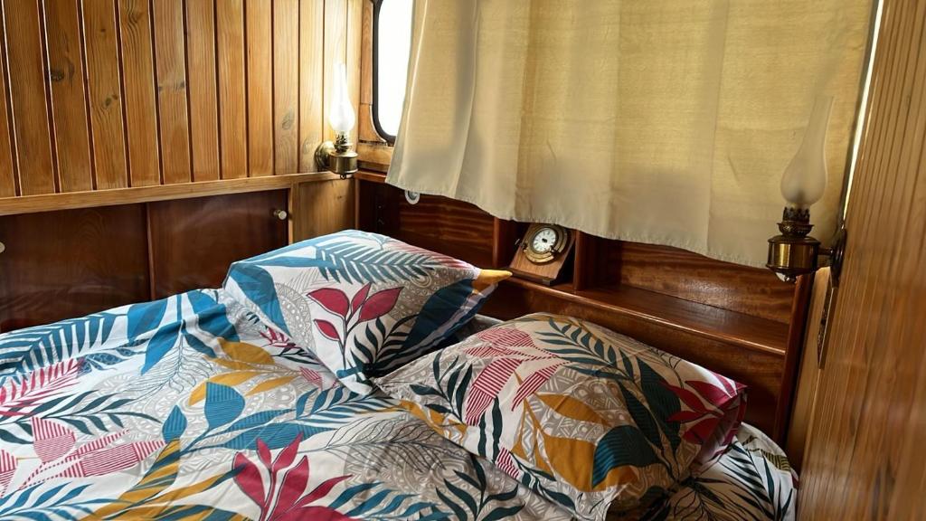 - un lit avec deux oreillers dans l'établissement L'Amazone - bateau à quai sur le canal de bourgogne, à Tanlay
