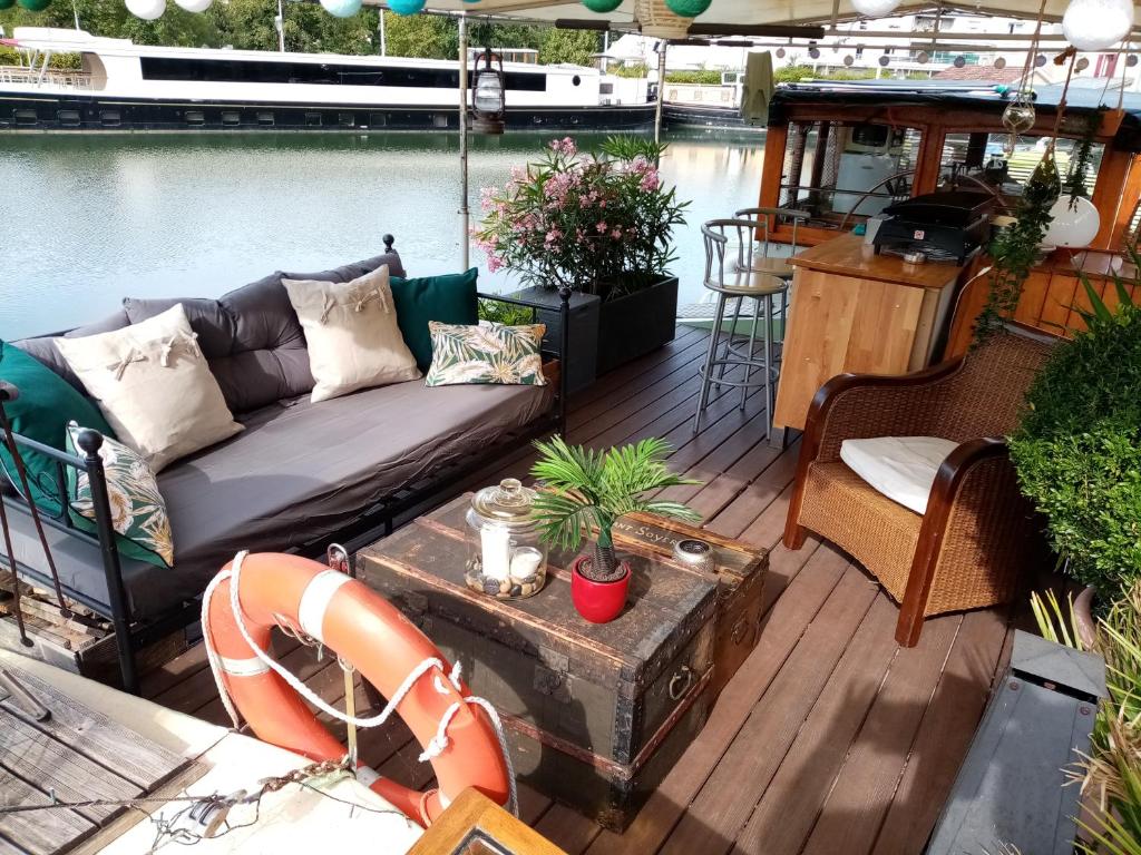 une terrasse couverte avec un canapé et une table sur un bateau dans l'établissement PENICHE ONDINE, à Plombières-lès-Dijon