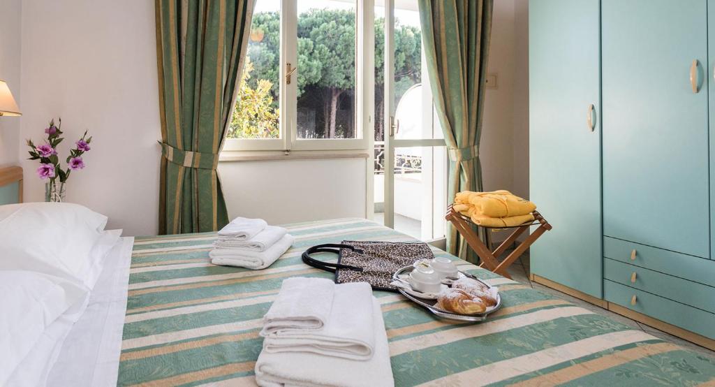 une chambre avec un lit avec un plateau de nourriture dessus dans l'établissement Hotel Bamby, à Cervia