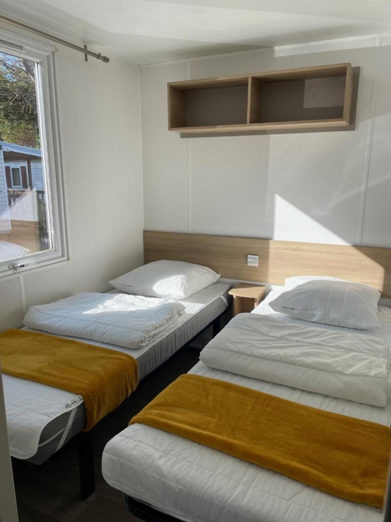 une chambre avec deux lits et une fenêtre dans l'établissement Joli Mobil home Camping 4 Le Bois Masson A34, à Saint-Jean-de-Monts