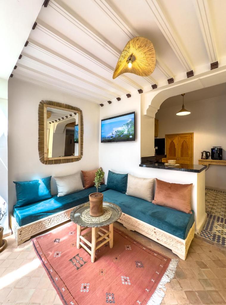 un salon avec un canapé bleu et une table dans l'établissement Riad & SPA Privé - La Perle d'Orane - Marrakech, à Marrakech