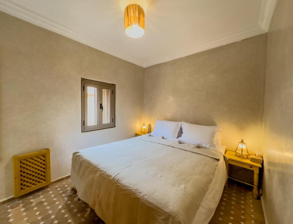 une chambre avec un grand lit et une fenêtre dans l'établissement Riad & SPA Privé - La Perle d'Orane - Marrakech, à Marrakech 37 autres photos