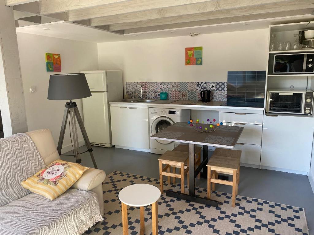 un salon avec un canapé et une table dans une cuisine dans l'établissement Gite d'ici et d'ailleurs 2 Maison proche Bordeaux et Bassin d Arcachon, à Saint-Morillon