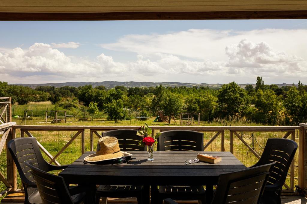 une table avec un chapeau assise au-dessus d'un balcon dans l'établissement L'Escale Occitane, à Alzonne