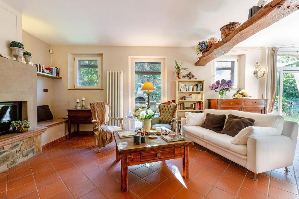 un salon avec un canapé blanc et une cheminée dans l'établissement Villa Ester, a Stylish Farmhouse on the Hills, à Capannori