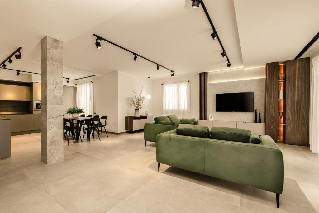 un salon avec des canapés verts et une salle à manger dans l'établissement Villa THE ONE - ZAvillas - up to 14 people, à Ponti sul Mincio