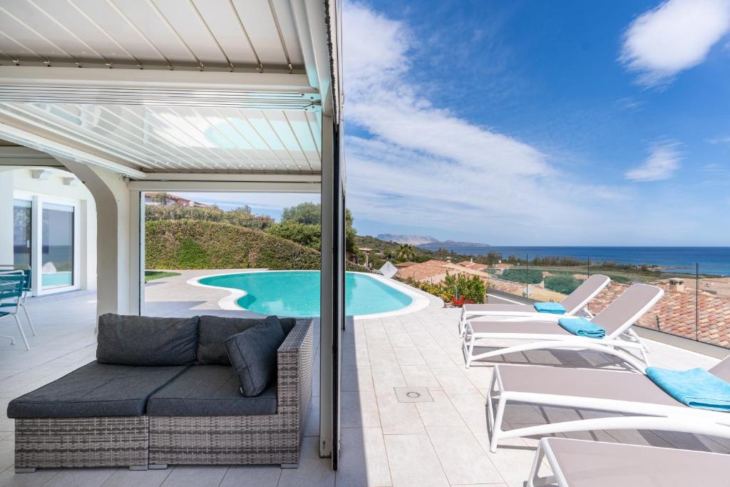 une terrasse avec des chaises longues et une piscine dans l'établissement Villa Smeralda, à San Teodoro