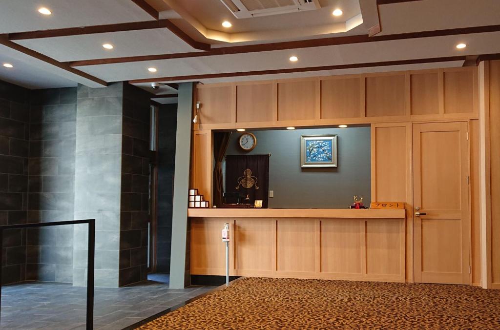 un hall d'entrée avec un bureau de réception et une porte dans l'établissement ホテル晴山, à Chikuma