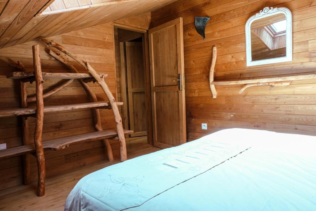 une chambre avec un lit dans une cabane en rondins dans l'établissement Gîte Nat'ure, à Mirabel