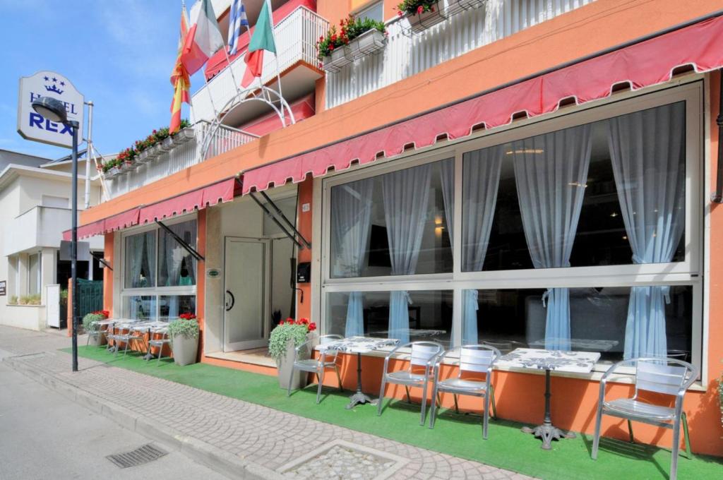 un restaurant avec des tables et des chaises à l'extérieur d'un bâtiment dans l'établissement Hotel Rex, à Caorle