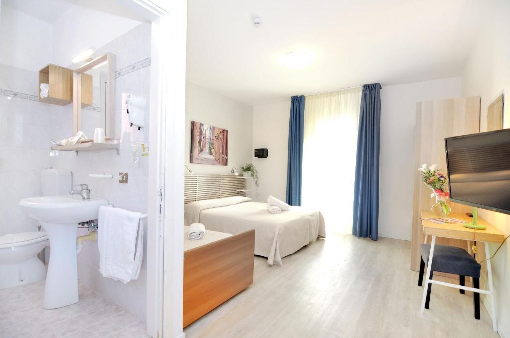 une salle de bain blanche avec un lavabo et des toilettes dans l'établissement Hotel Rex, à Caorle