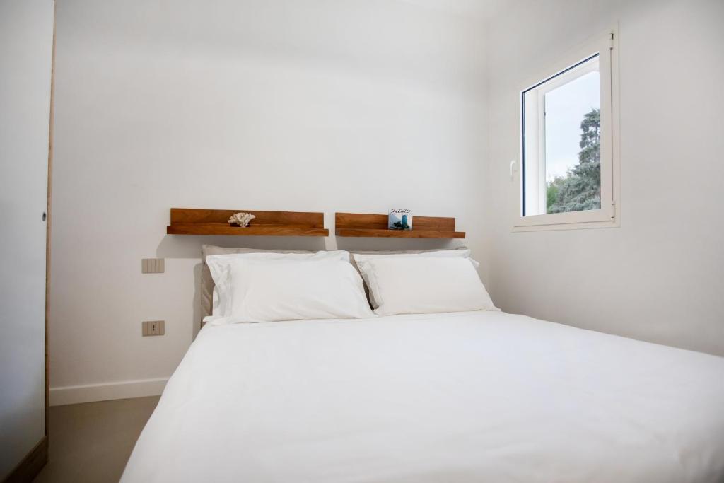 une chambre avec un lit blanc et une fenêtre dans l'établissement Pool Villa by Le Dune Villas, à Porto Cesareo 36 autres photos