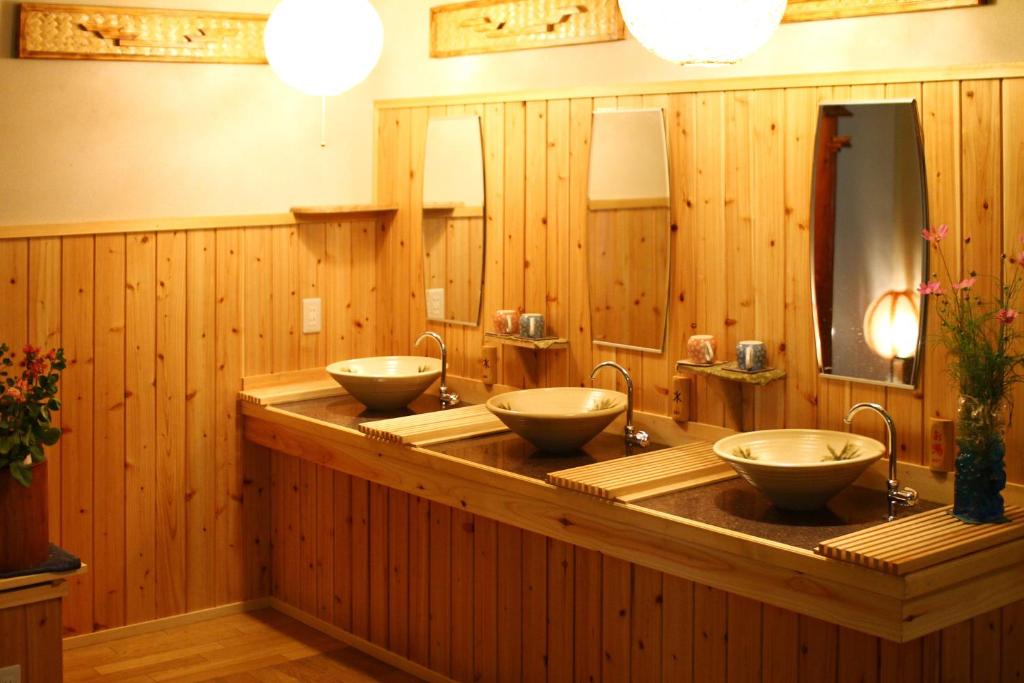 une rangée de trois lavabos dans une salle de bain en bois dans l'établissement Mogamiya Ryokan, à Shiroishi