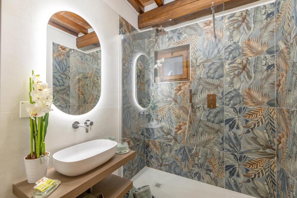 une salle de bain avec un lavabo et un miroir dans l'établissement Corte della Luna, à Cortone 60 autres photos