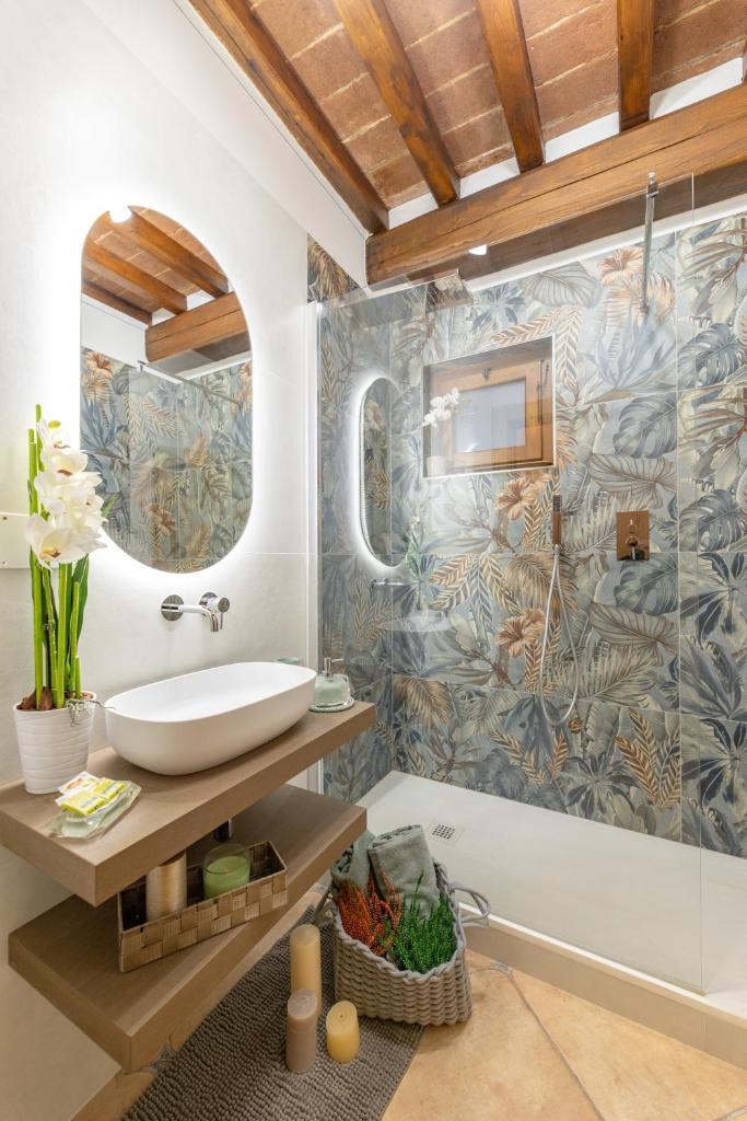 une salle de bain avec un lavabo, un miroir et une baignoire dans l'établissement Corte della Luna, à Cortone