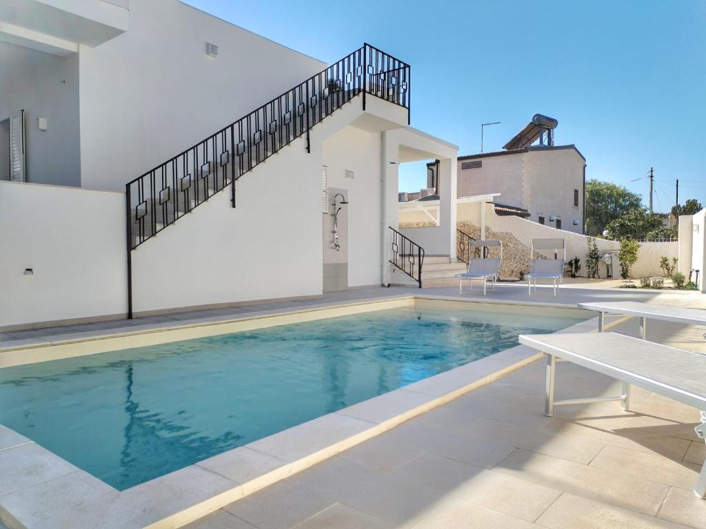 une piscine devant une maison dans l'établissement Villa Ina Lux, à Fontane Bianche