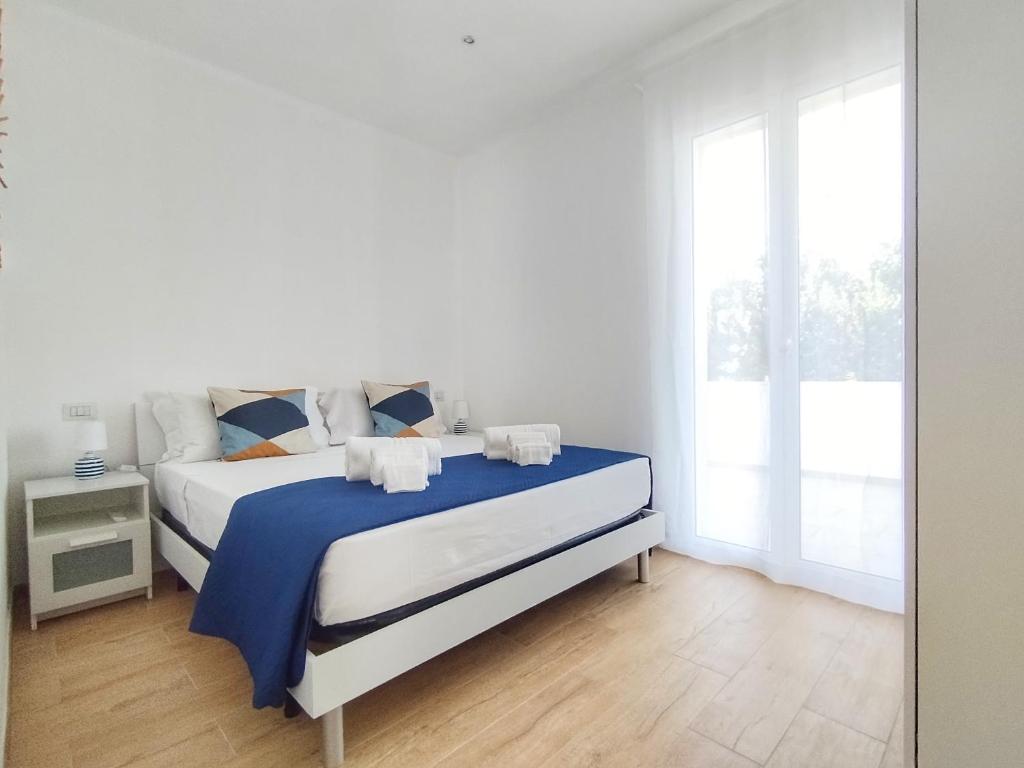 une chambre blanche avec un lit et une fenêtre dans l'établissement Villa Ina Lux, à Fontane Bianche