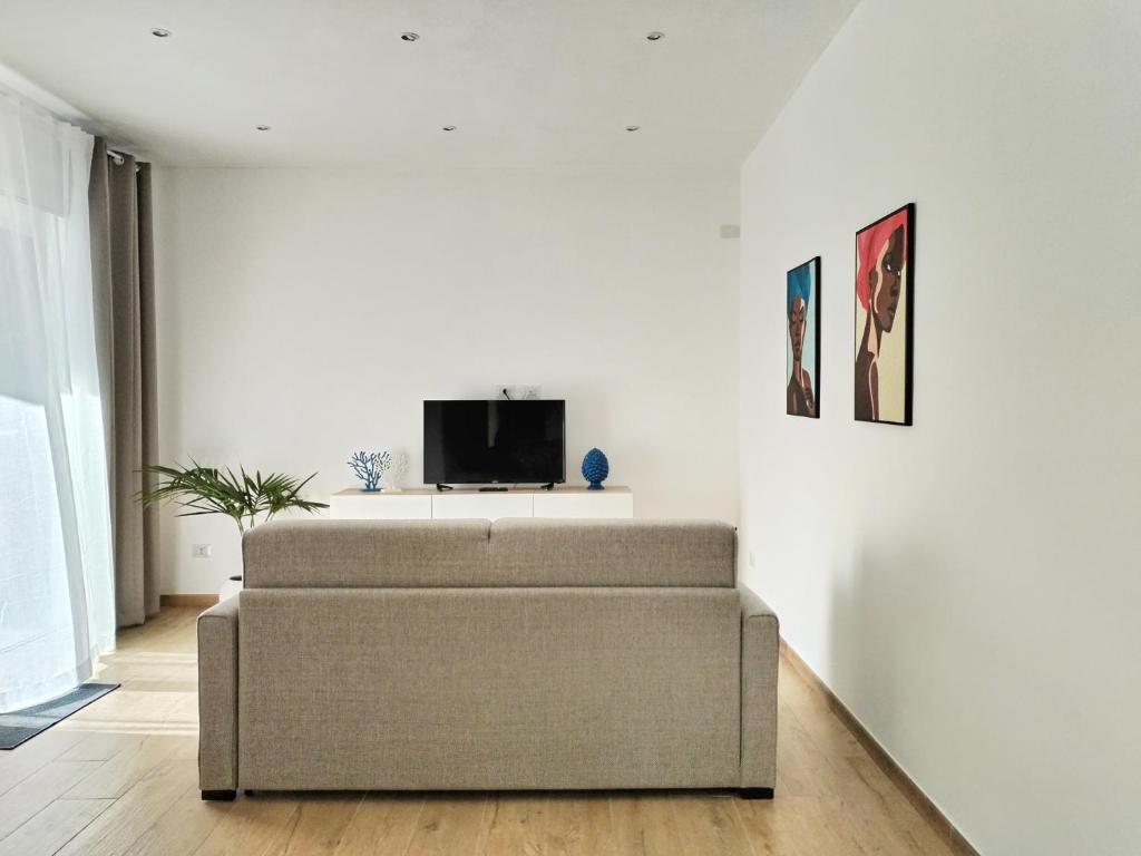 un salon avec un canapé et une télévision dans l'établissement Villa Ina Lux, à Fontane Bianche