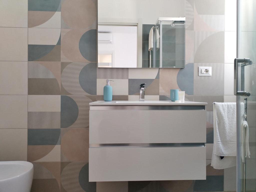 une salle de bain avec un lavabo blanc et un miroir dans l'établissement Villa Ina Lux, à Fontane Bianche