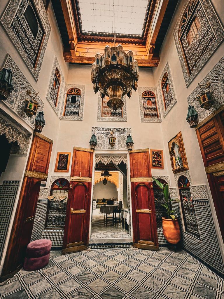 une grande chambre avec un lustre et une salle à manger dans l'établissement Riad Rasia, à Fès