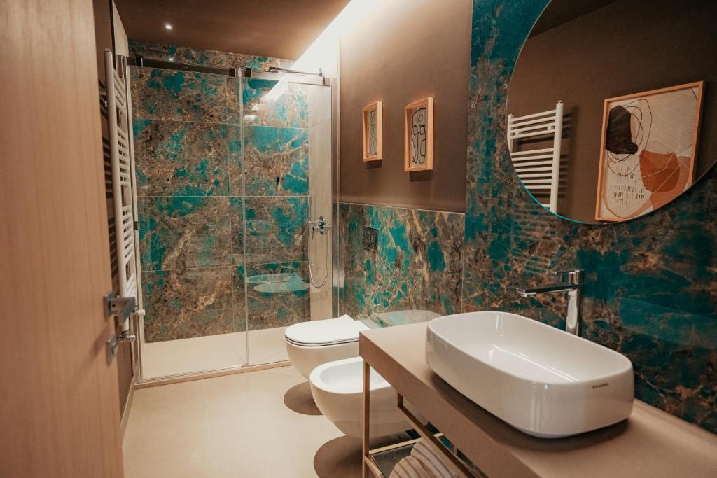 une salle de bain avec un lavabo, des toilettes et un miroir dans l'établissement Lumia Hotel, à Termoli