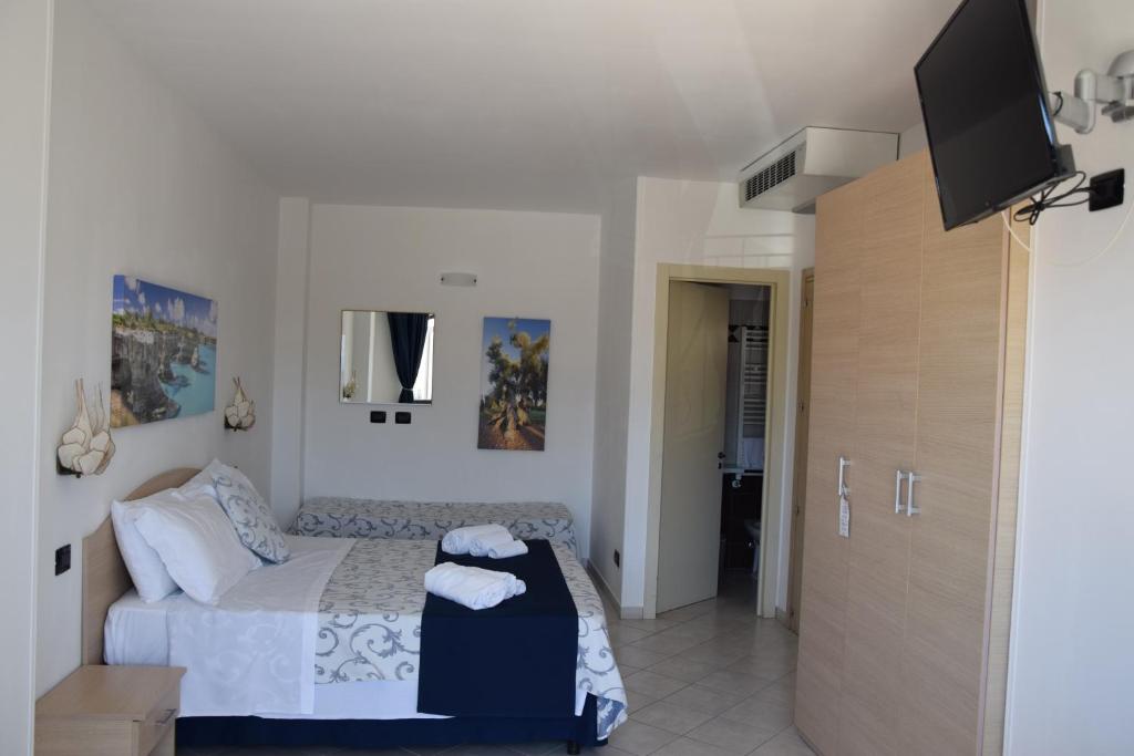 une chambre avec un lit et une télévision à écran plat dans l'établissement Hotel Profumo Di Mare, à Otrante
