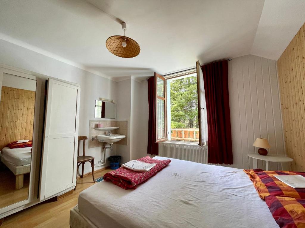 une chambre avec un lit, un lavabo et une fenêtre dans l'établissement Gîte montagne 1 à 25 places "Chalet Coste Belle", à Ceillac