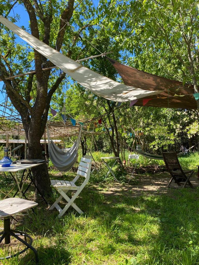 d'un hamac ainsi que d'une table et de chaises sous un arbre. dans l'établissement Yourte à La Campagnette, à Montpellier