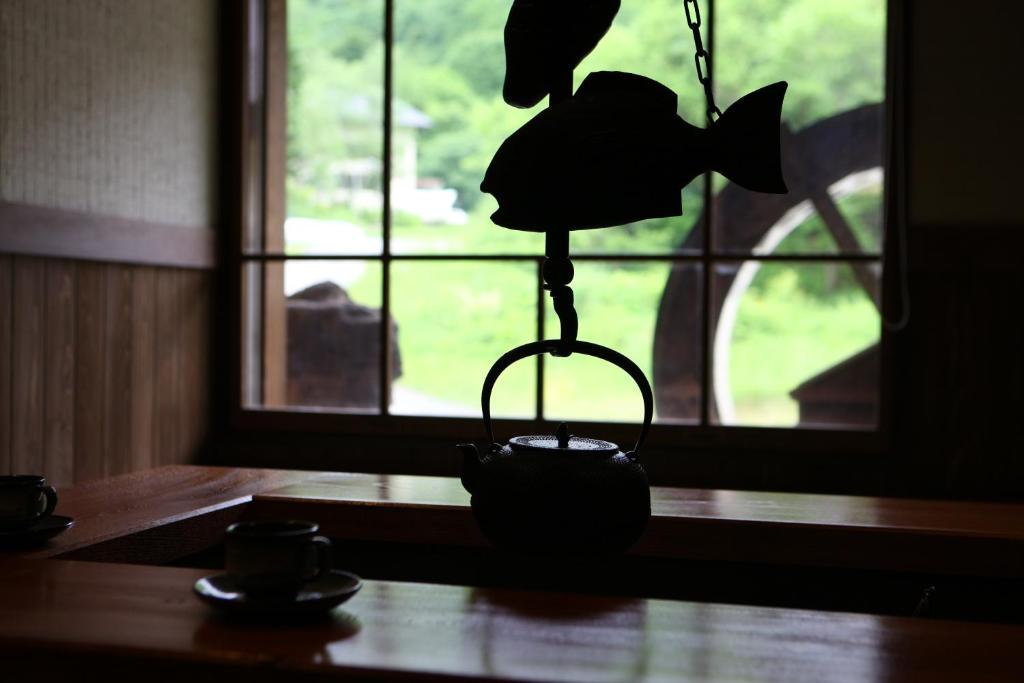 une lampe assise sur une table devant une fenêtre dans l'établissement 志賀高原 白い温泉 渓谷の湯, à Yamanouchi