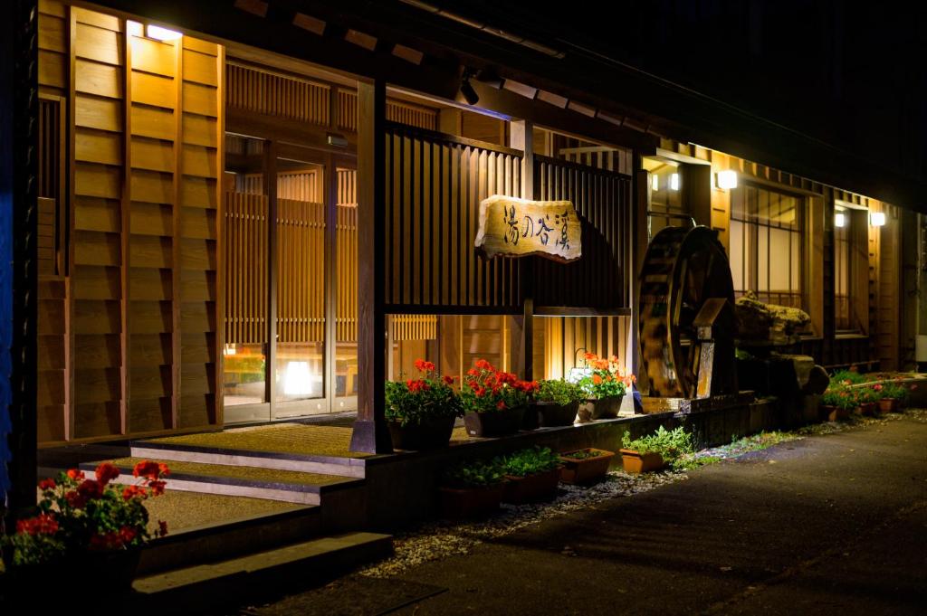 un bâtiment avec des plantes en pot devant lui la nuit dans l'établissement 志賀高原 白い温泉 渓谷の湯, à Yamanouchi 132 autres photos