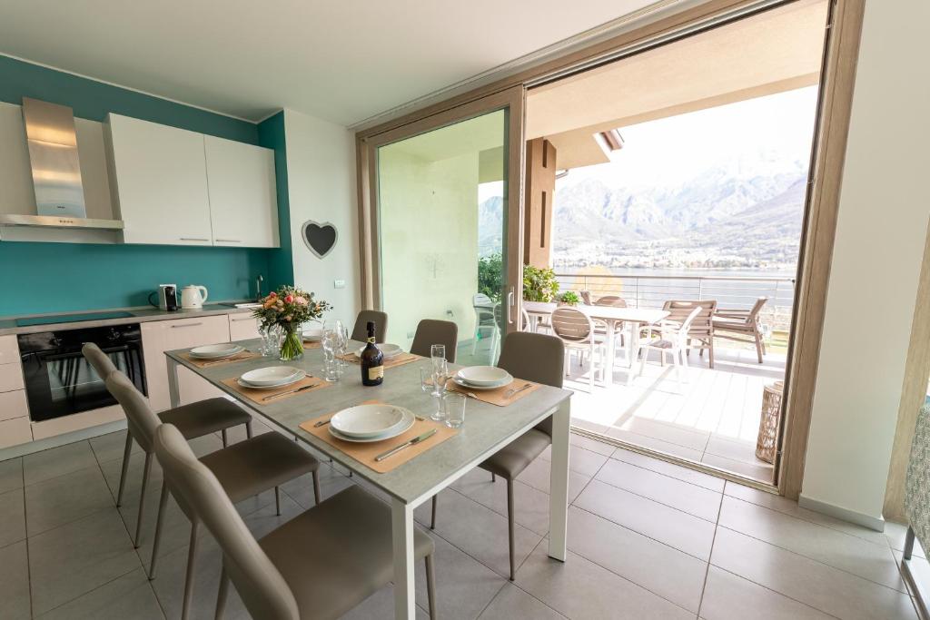 Il comprend une cuisine et une salle à manger avec une table et des chaises. dans l'établissement Bellagio Village - Holiday Apartments by the Lake - Seasonal Warm Pool and Sauna, à Oliveto Lario