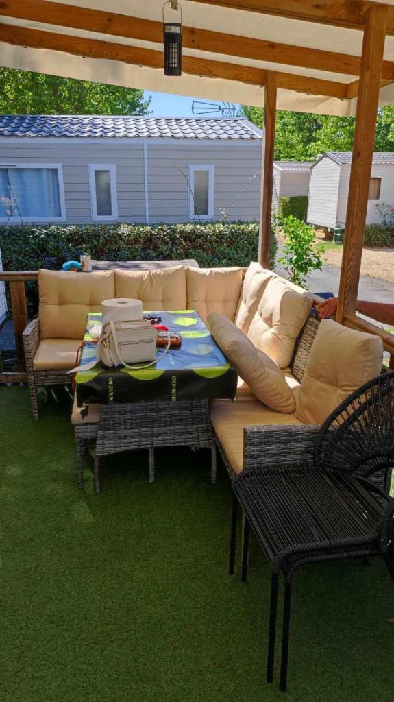 un patio avec un canapé, une table et des chaises dans l'établissement Camping sable du midi 4 etoiles, à Valras-Plage 3 autres photos