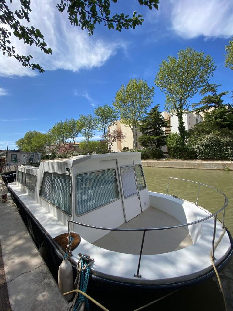 un bateau est amarré à un quai dans l'eau dans l'établissement Bateau Mama Mia, à Narbonne