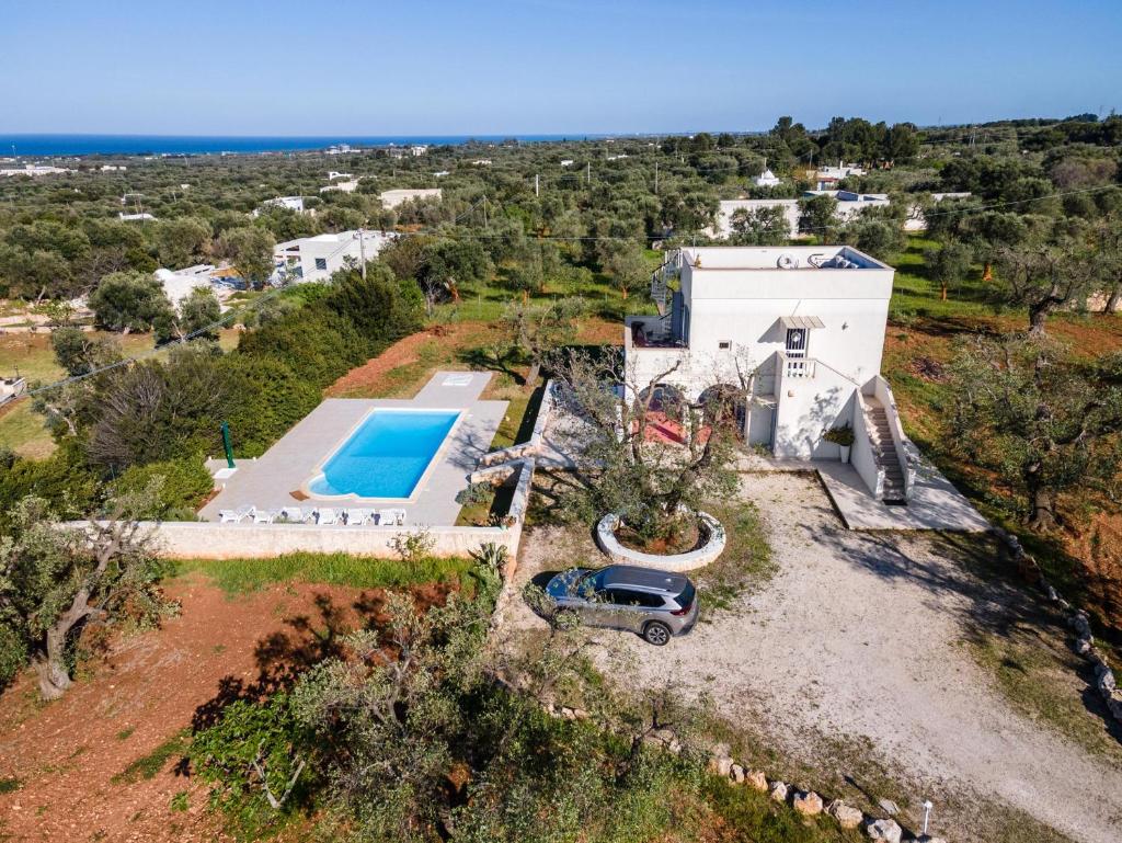 - une vue aérienne sur une maison avec une piscine et une voiture dans l'établissement Villa Sierri by Perle di Puglia, à Specchiolla