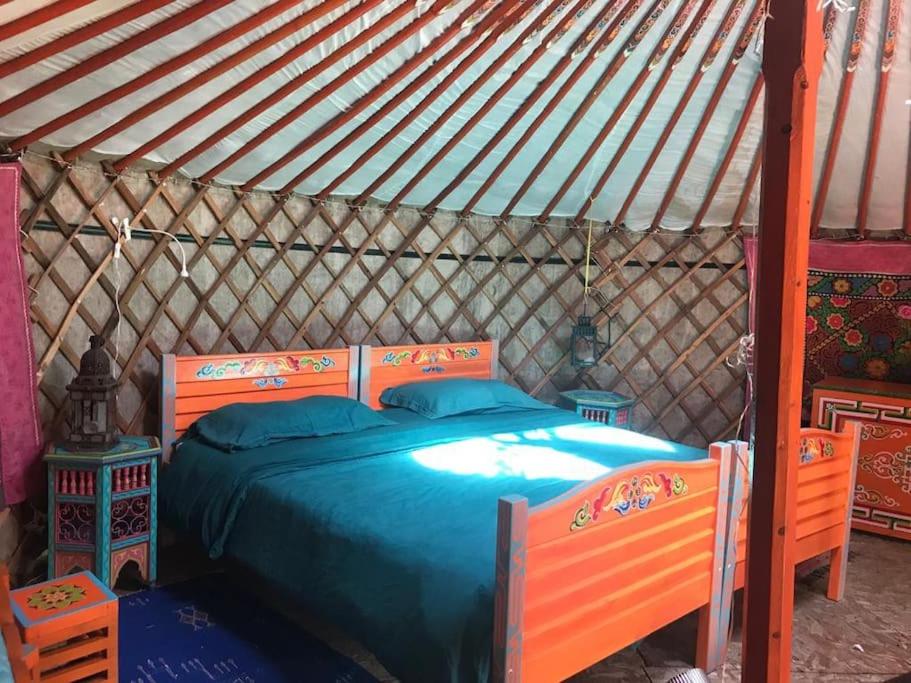- une chambre avec un lit bleu dans une yourte dans l'établissement Yourte de la bas, à Curienne