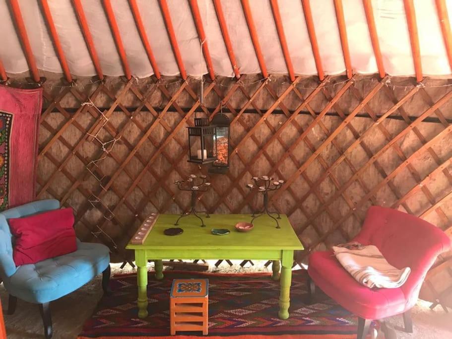 une yourte avec une table verte et deux chaises dans l'établissement Yourte de la bas, à Curienne