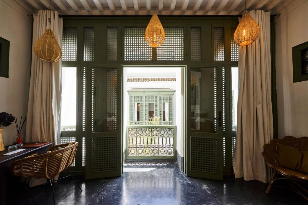 Cette chambre dispose d'une porte ouverte sur un balcon. dans l'établissement Riad Dar Nakous, à Marrakech