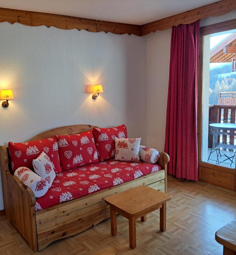 - un salon avec un canapé rouge et une fenêtre dans l'établissement Appartement avec balcon - 2 personnes, à Puy-Saint-Vincent