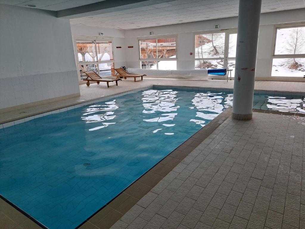 une grande piscine avec de l'eau bleue dans un immeuble dans l'établissement Appartement avec balcon - 2 personnes, à Puy-Saint-Vincent
