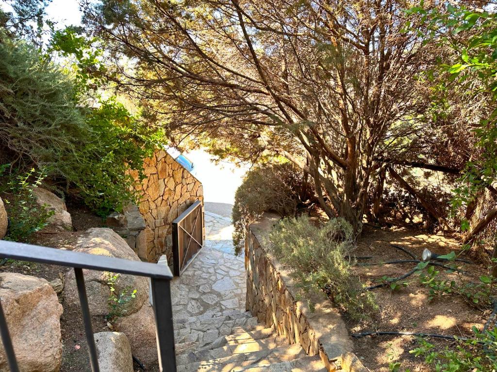 un escalier avec une porte sur un mur de pierre dans l'établissement Villa Nais - Premium Villa, à Chia