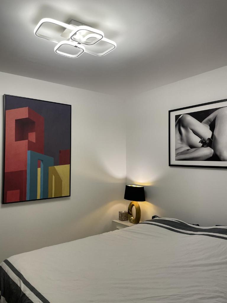 une chambre avec un lit et un tableau au mur dans l'établissement Chambre suite privée à Boulogne, à Boulogne-Billancourt