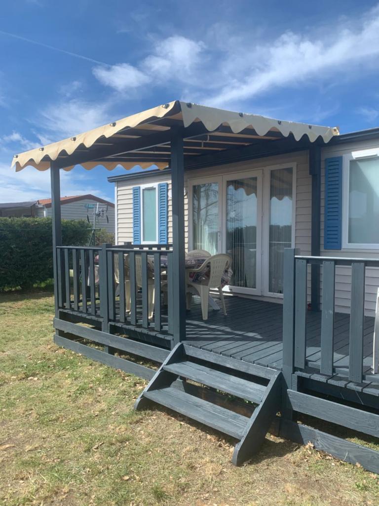 une terrasse en bois avec pergola sur une maison dans l'établissement Flo mobil home camping Poney trois étoiles route de Moustiers Ste Croix, à Sainte-Croix-de-Verdon