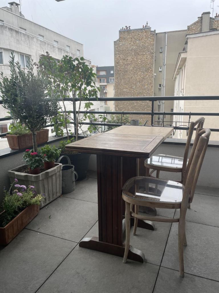 d'une table en bois et d'une chaise sur un balcon. dans l'établissement Chambre suite privée à Boulogne, à Boulogne-Billancourt