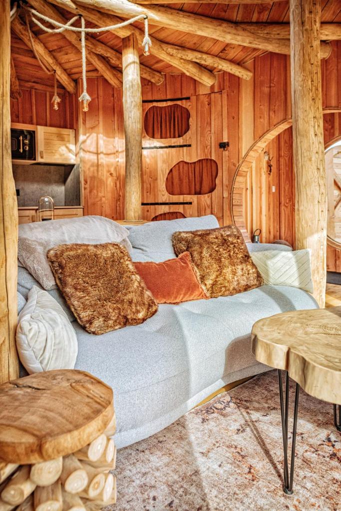 un grand lit dans une chambre aux murs en bois dans l'établissement La Cabane Korrigans, à Gommené